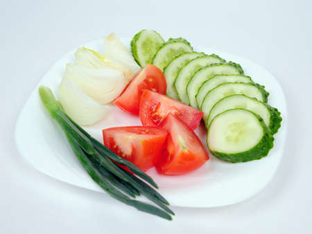 Onions, tomatoes and cucumbers on a plateの写真素材