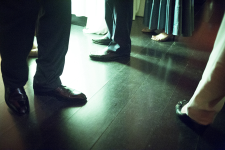 Legs of men and lady wearing standing on shiny tile floor in social event wedding marriage party in...
