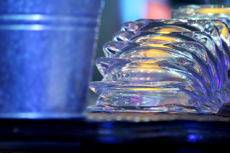 Color photo of a group of upturned clear glass cigarette ash trays sparkling in the lightの写真素材