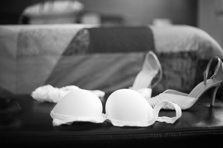 Wedding bridal garter belt, bra lingerie and white shoes in Madrid Spain. Black and white photo with shallow depth of focus.の写真素材