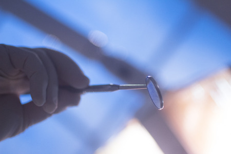 Dental instrumentation dentist drill tooth dental cleaning tool in the hand of dentist in dentists surgery clinic artistic color photo with low depth of focus.の写真素材