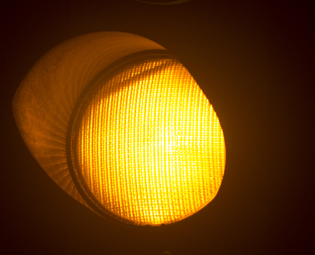 Orange amber traffic light photo at night on black background.の写真素材