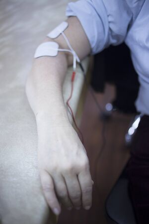 Female patient arm in physiotherapy rehabiliation treatment from injury in hospital clinic with...