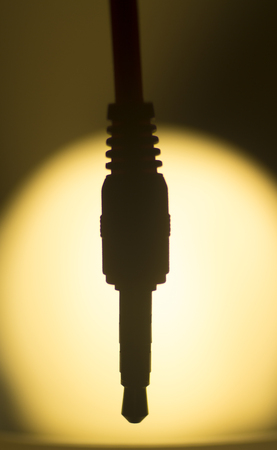 Audio cable artistic silhouette in circular light vignette photograph.