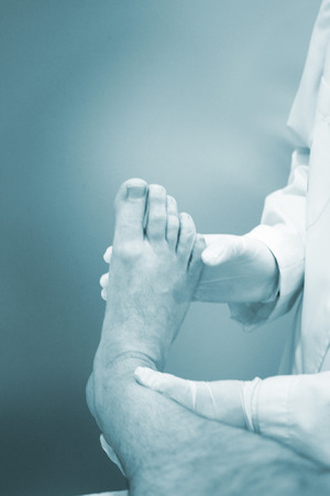 Male Traumatologist orthopedics surgeon doctor examining middle aged man patient to determine injury, pain, mobility and to diagnose medical treatment.の写真素材