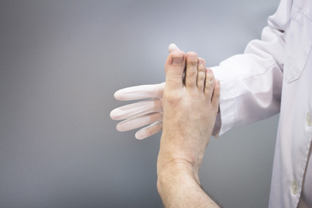 Male Traumatologist orthopedics surgeon doctor examining middle aged man patient to determine injury, pain, mobility and to diagnose medical treatment.の写真素材