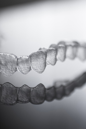 Invisible Invisalign plastic dental teeth brackets tooth braces isolated with shallow depth of focus...