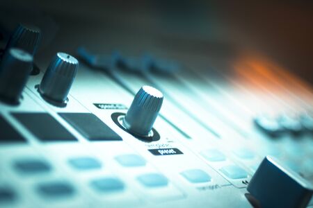 DJ console cd mp4 deejay mixing desk buttons and knobs in Ibiza house techno dance music wedding reception party in nightclub with colored lighting effect disco lights.の写真素材