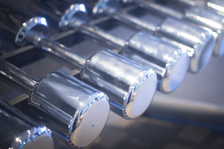 Dumbbell gym metal weights rack in exercise room in sports bodybuilder gym health club fitness studio for bodybuilding and weight training.の写真素材