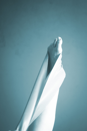 Pilates stretching leg hamstring foot achiles tendon yoga flexibility postural rubber band posture blue flexible strap health club held by young woman exercising.の写真素材