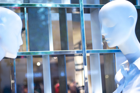 Shop bald dummy fashion mannequin in store boutique shop window artistic photo.