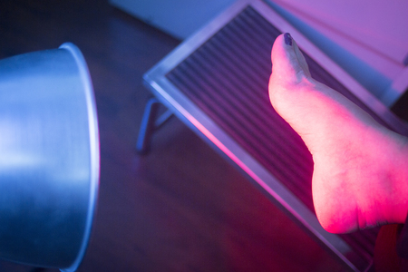 Patient foot in red physiotherapy heat treatment under hot light.の写真素材