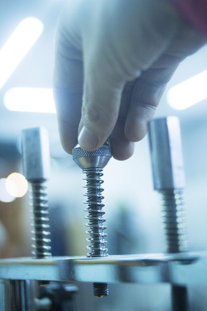 Hand, wrist and fingers physiotherapy rehabilitation treatment from orthopedic surgery in a hospital clinic physiotherapists room turning a screw to build strength in his finger, hands and wrists muscles.の写真素材