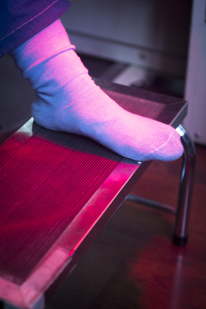 Patient foot in red physiotherapy heat treatment under hot light.の写真素材