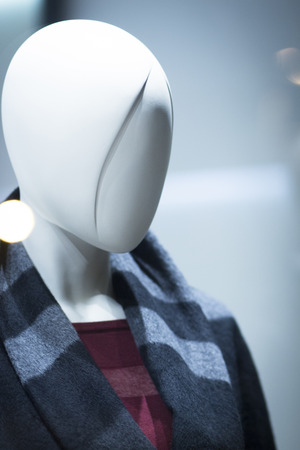 Shop dummy fashion mannequin in department store boutique window wearing current trends in garments.の写真素材