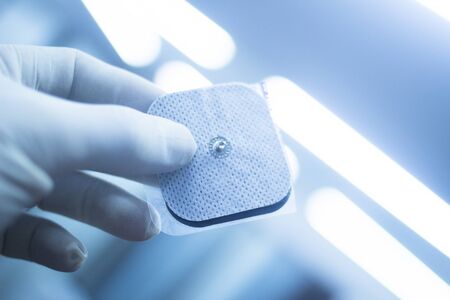 Electro physiotherapy electrical impulse stimulation rehabiliation treatment from injury in hospital clinic patch with electrical stimulus.の写真素材