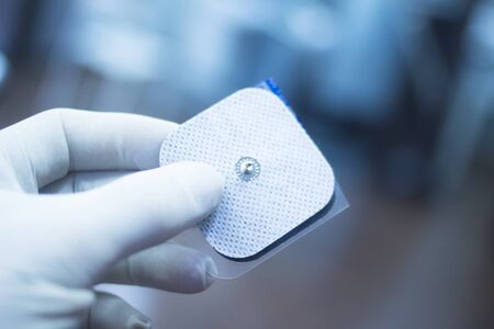 Electro physiotherapy electrical impulse stimulation rehabiliation treatment from injury in hospital clinic patch with electrical stimulus.の写真素材