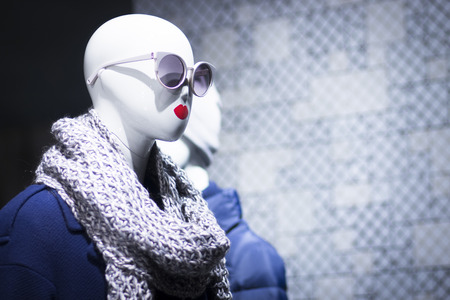 Shop dummy fashion mannequin in department store boutique window wearing current trends in garments.の写真素材