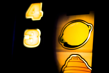 One arm bandit slot machine reels showing numbers in casino at night photograph.