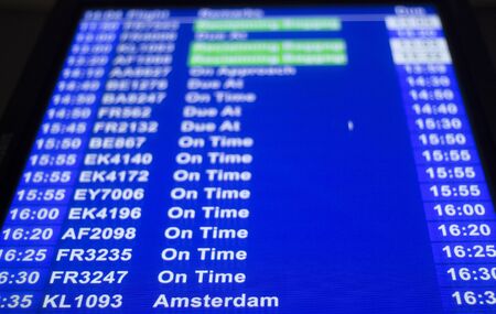 Airport departures arrivals board  light panel board giving information about flights showing on time.のeditorial素材