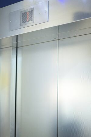 Metal elevator lift doors in airport lounge photo.