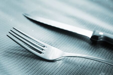 Knife and fork on dinner table place setting in restaurant wedding party photo.の写真素材