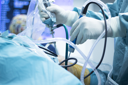 Knee arthroscopy orthopedic surgery operation in hospital operating room photo showing surgeon with...