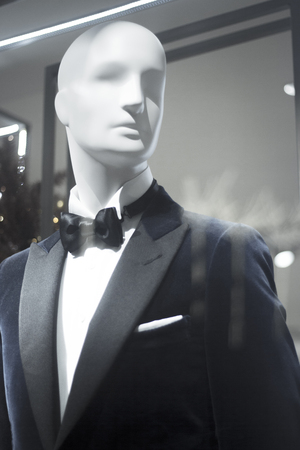 Shop dummy fashion mannequin in department store boutique window wearing evening suit dinner jacket and bow tie.の写真素材