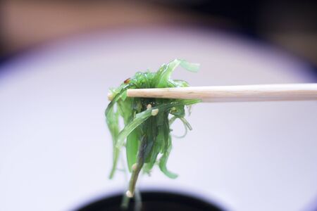 Japanese restaurant sushi oriental seaweed sushi como wakame food dish in bowl and traditional Asian wooden chopsticks photo.の写真素材