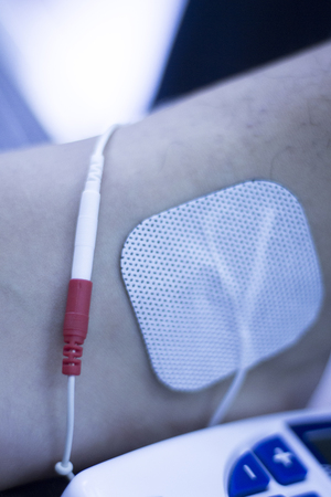 Physical therapy clinic of hospital. Patient having electrical impulse physiotherapy treatment for...