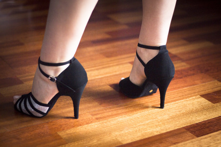 Female ballroom, standard, sport dance, latin and salsa dancer feet and shoes in dance academy school rehearsal room dancing salsa.の写真素材