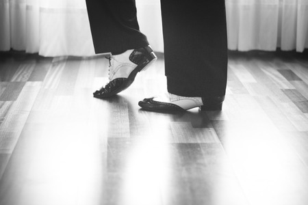 Male ballroom, standard, sport dance, latin and salsa dancer feet and shoes in dance academy school rehearsal room dancing jazz fusion.の写真素材