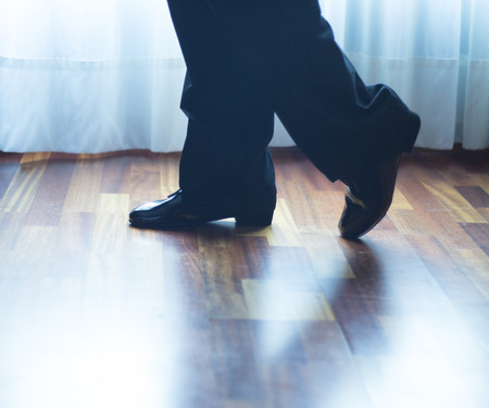 Male ballroom, standard, sport dance, latin and salsa dancer feet and shoes in dance academy school rehearsal room dancing salsa.の写真素材