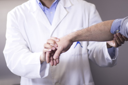 Traumatology and orthopedics surgeon in doctor and patient orthopedic medical examination consultation for hand, fingers, arm and wrist in hospital clinic.の写真素材