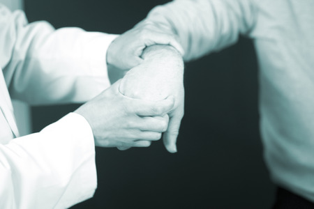 Traumatology and orthopedics surgeon in doctor and patient orthopedic medical examination consultation for hand, fingers, arm and wrist in hospital clinic.の写真素材