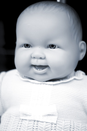 Baby toy doll fashion store mannequin in shop window in clothes smiling photograph.の写真素材