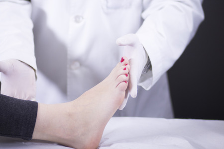 Traumatology and orthopedics surgeon in doctor and female young patient orthopedic medical examination consultation of foot, ankle and toes in hospital clinic.の写真素材
