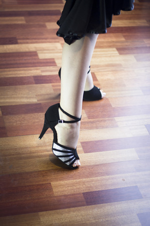 Female ballroom, standard, sport dance, latin and salsa dancer feet and shoes in dance academy school rehearsal room dancing salsa.の写真素材
