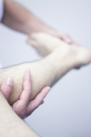 Myofascial osteopathy physiotherapy treatment by physiotherapist and osteopath in physical therapy rehabilitation treatment on patient on leg and knee joint.の写真素材