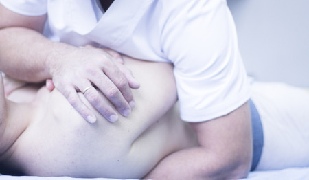 Myofascial osteopathy physiotherapy treatment by physiotherapist and osteopath in physical therapy rehabilitation treatment on patient on back.の写真素材