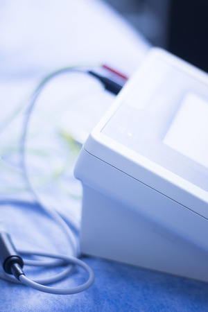Electroacupunture cables connecting machine to needles used by acupunturist on patient in pain and...