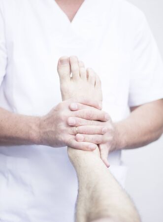 Myofascial osteopathy physiotherapy treatment by physiotherapist and osteopath in physical therapy rehabilitation treatment on patient on leg, ankle and foot.の写真素材