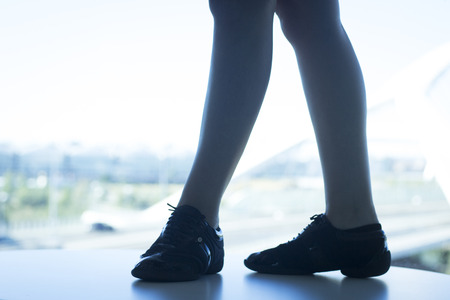 Woman dance fit teacher giving dancing class in gym in silhouette by window.の写真素材