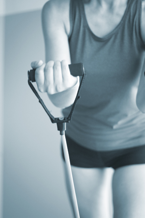 Woman with slim, fit and attractive body in 40's exercising with resistance exercise bands in gym bicep exercise.の写真素材
