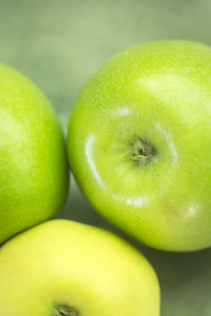 Three fresh green apples on metal fruit bowl dish.の写真素材