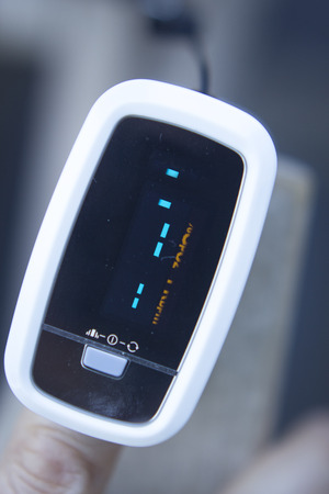 Portable hand held domestic cardiac finger pulse rate meter to show resting heart rate in monitored patient.の写真素材