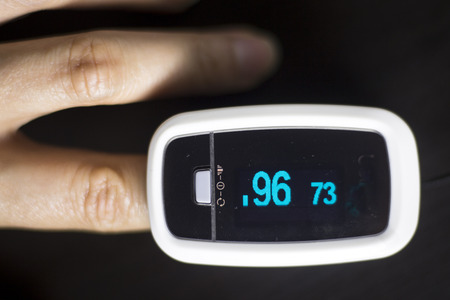 Portable hand held domestic cardiac finger pulse rate meter to show resting heart rate in monitored patient.の写真素材
