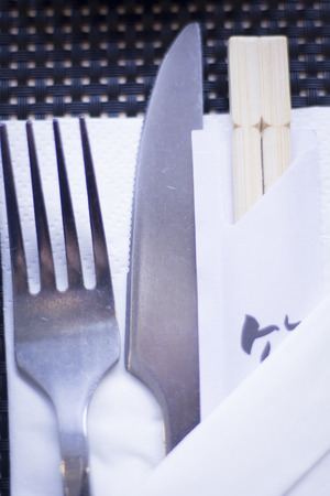 Asian chopsticks and knife and fork in Japanese restaurant to eat sushi and oriental cuisine.の写真素材