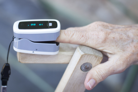 Portable hand held domestic cardiac finger pulse rate meter to show resting heart rate in monitored patient.の写真素材