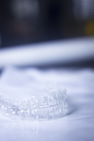 Invisible teeth aligner cosmetic orthodontic brackets used to straighten and align teeth in patient with clear plastic see through aesthetic look.の写真素材